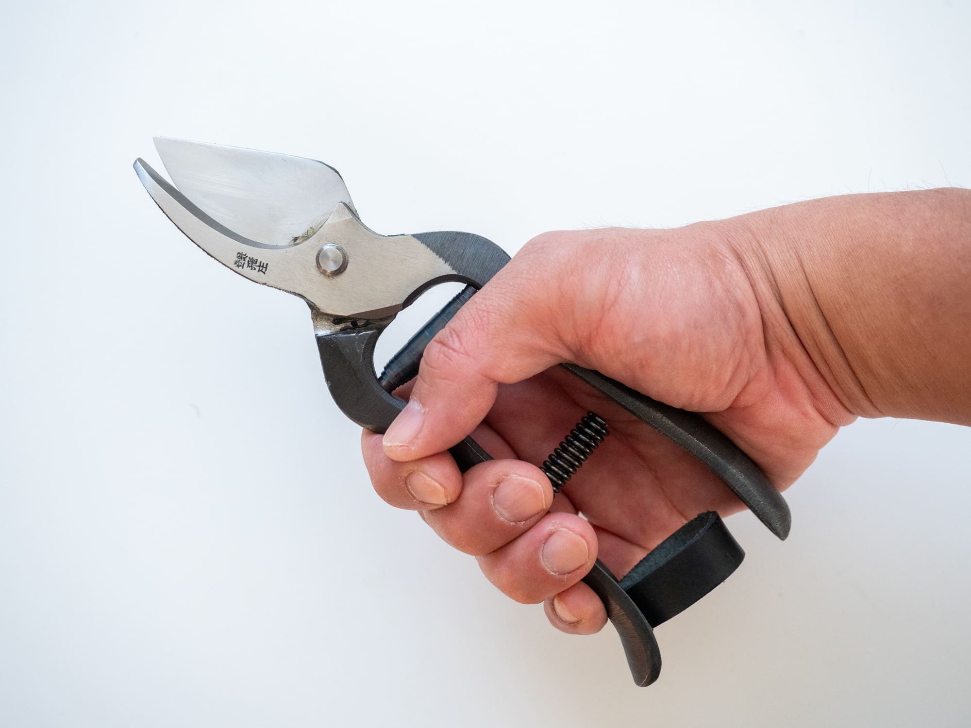 A hand gripping the Tobisho Hiryu Alpha handle, showing how the raised heel sits under the little finger, forged in Yamagata Japan